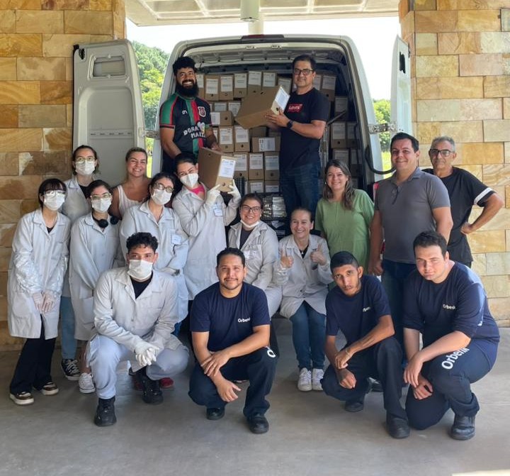 Carro carregado com caixas de arquivo e equipe em frente ao Espaço Multiuso