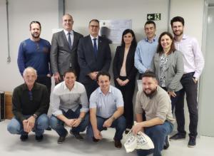 Cinco homens e duas mulheres estão de pé, lado a lado. À frente, quatro homens estão agachados lado a lado.